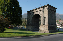 Arco d'Augusto con prato verde e alberi