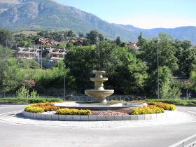 rotatoria decorata con fiori e fontana di pietra